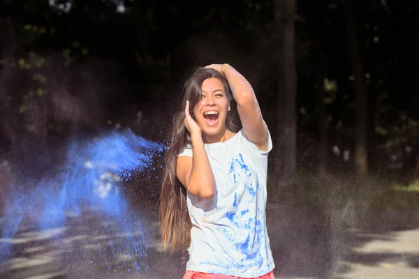 Feliz morena mujer asiática con el pelo largo jugando con Holi azul — Foto de Stock