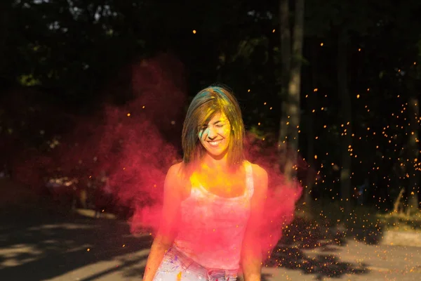 Feliz mujer bronceada con el pelo corto posando con Holi re explosión — Foto de Stock