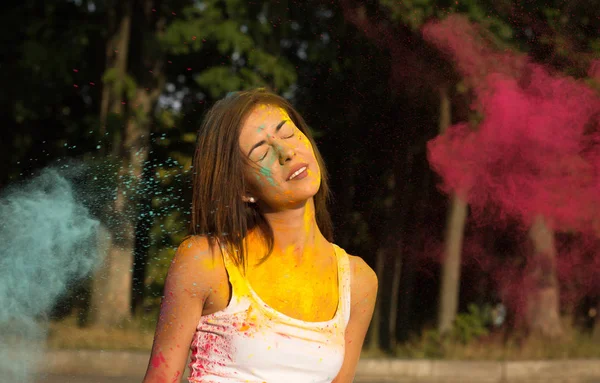 Mujer joven tierna con el pelo corto jugando con la explosión Holi r — Foto de Stock