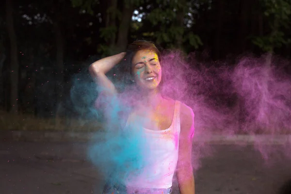 Joven alegre con el pelo corto posando con Holi pi explotando — Foto de Stock