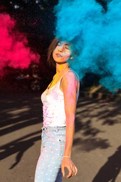 Lovely brunette woman with short hair posing with exploding Holi — Stock Photo, Image