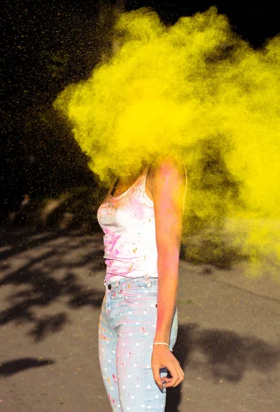 Mujer delgada con pelo corto jugando con amarillo explosivo Holi p — Foto de Stock