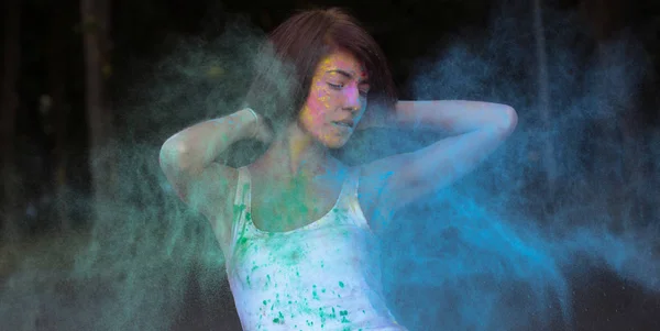 Gorgeous young woman with short hair posing with exploding Holi — Stock Photo, Image