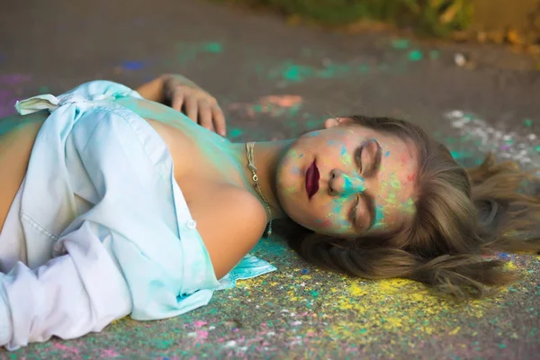 Тендерна молода жінка з закритими очима покриті холі фарбою, лежачи на — стокове фото