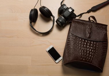 Kadının deri sırt çantası, kulaklık, fotoğraf makinesi yatıyordu düz bir