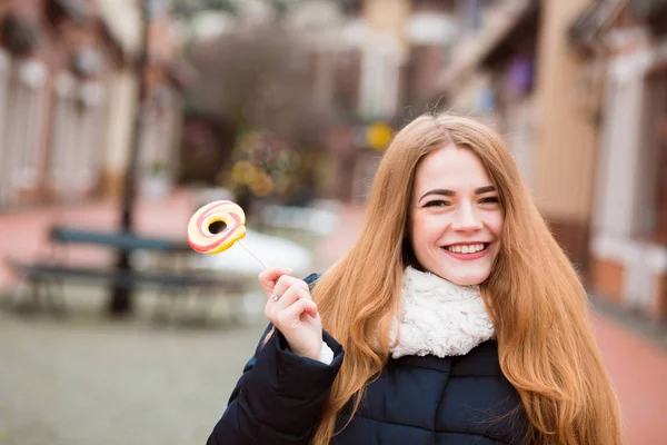 Happy blonde woman with long hair holding colorful lollipop at t — Stock Photo, Image