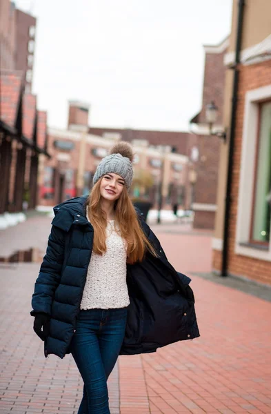 Mulher loira bonita em chapéu de malha e casaco posando perto do shopping — Fotografia de Stock