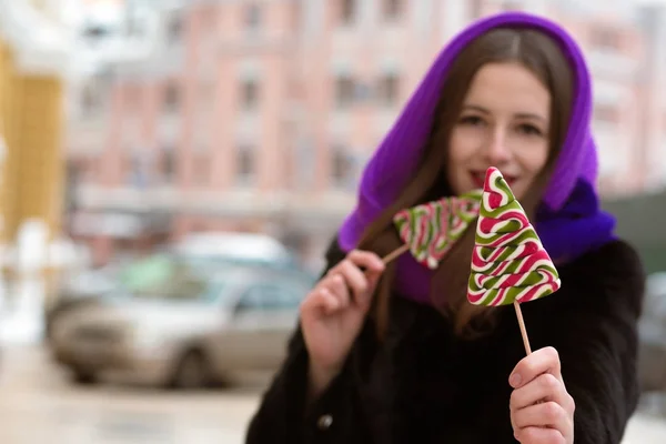 Lovely brunette woman in purple scarf holding colorful Christmas — Stock Photo, Image