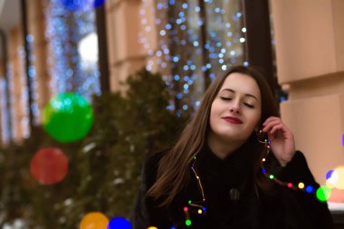 Güzel genç kadın uzun saçlı renkli garland inci holding