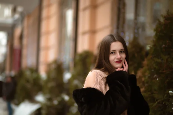 Awesome brunette woman wearing warm coat and posing near the spr — Stock Photo, Image