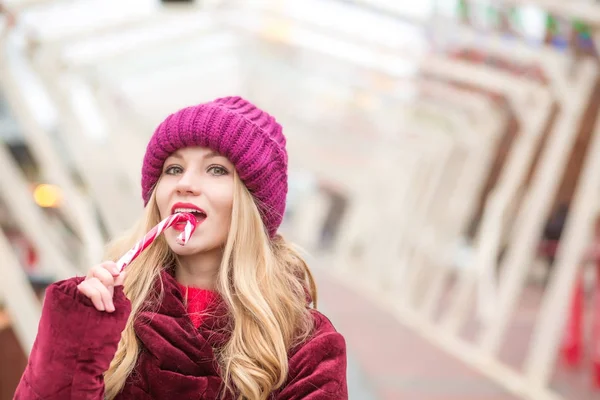 Pretty blonde girl in red knitted hat posing with Christmas cand — Stock Photo, Image