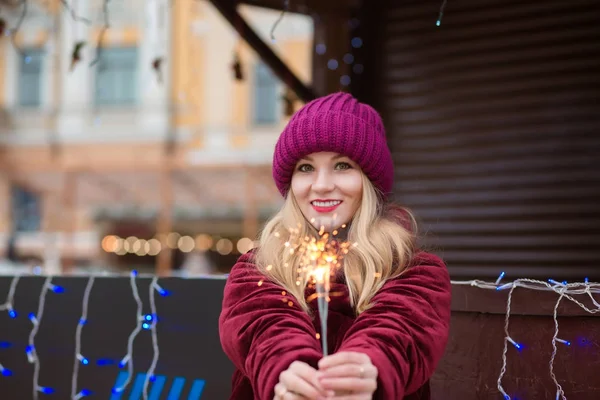 Merry blonde woman dressed in red knitted hat and warm coat hold — Stock Photo, Image