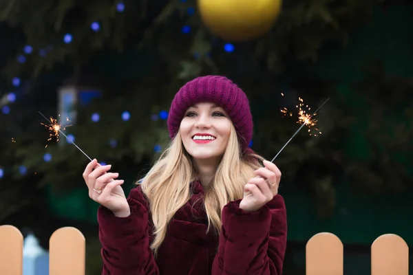 Adorable blonde woman dressed in knitted hat and warm coat holdi — Stock Photo, Image