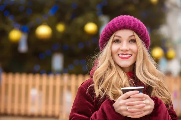 Positive young woman dressed in winter clothes and drinking coff — Stock Photo, Image