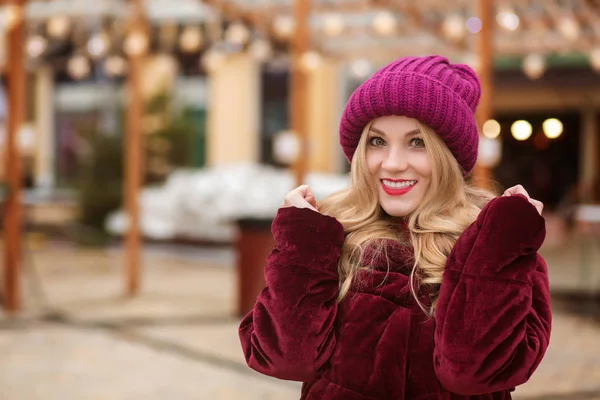 Happy blonde woman wearing warm winter clothes, posing on the ba — Stock Photo, Image
