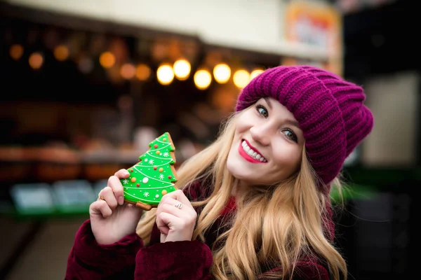 Mujer joven positiva sosteniendo galleta de jengibre, posando en la C — Foto de Stock