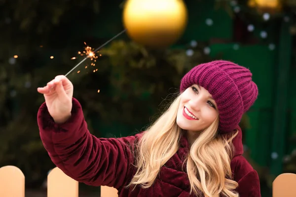 Happy young woman dressed in knitted hat and warm coat holding g — Stock Photo, Image