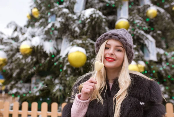 Mujer joven feliz en sombrero de punto gris sosteniendo delicioso chocolate — Foto de Stock