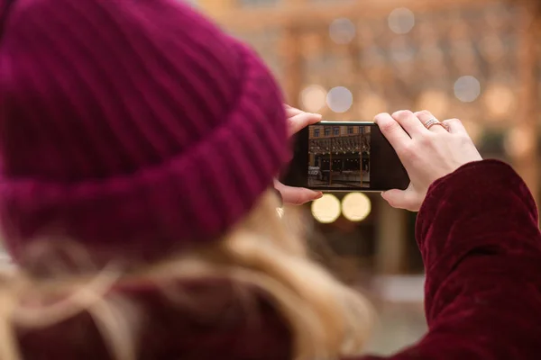 Wanita mengambil foto di ponsel dengan latar belakang cahaya di th — Stok Foto
