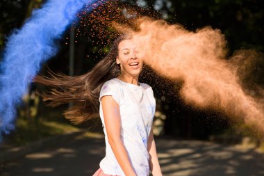 Güzel genç Asyalı kadın Holi boya patlayan ile eğleniyor