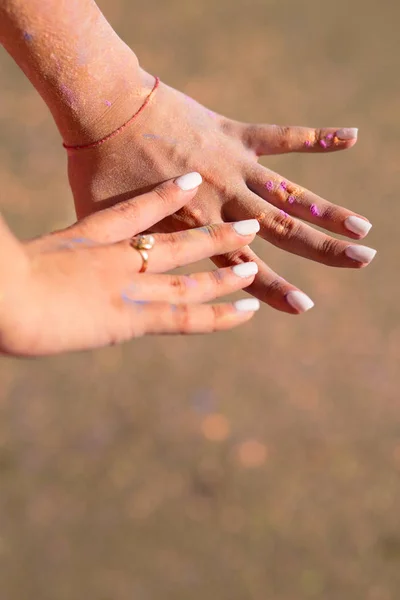 Female hands covered with Holi color powder