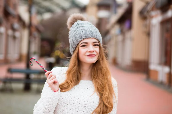 Stylish red haired woman in trendy apparel holding tasty Christm — Stock Photo, Image