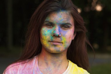 Genç kadın mavi ve sarı kuru Gulal toz poz ile kaplı