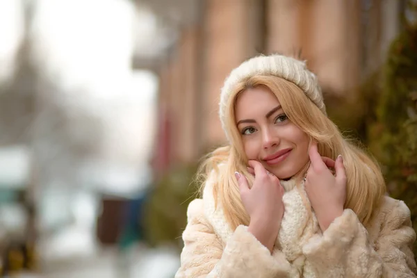 Pleased blonde girl in warm apparel with natural makeup posing a — Stock Photo, Image