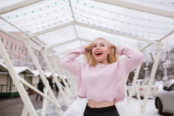 Cool blonde woman with bright makeup, wearing pink sweater, posi — Stock Photo, Image