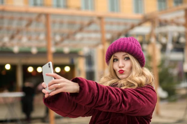 Fresco donna bionda vestita con vestiti caldi facendo selfie al b — Foto Stock