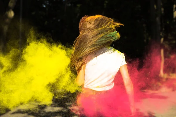 Mujer rubia delgada con viento en el pelo y colores vibrantes explotando — Foto de Stock