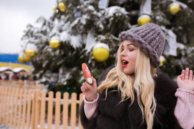 Gri örgü şapka lezzetli cin tutan çekici genç kadın