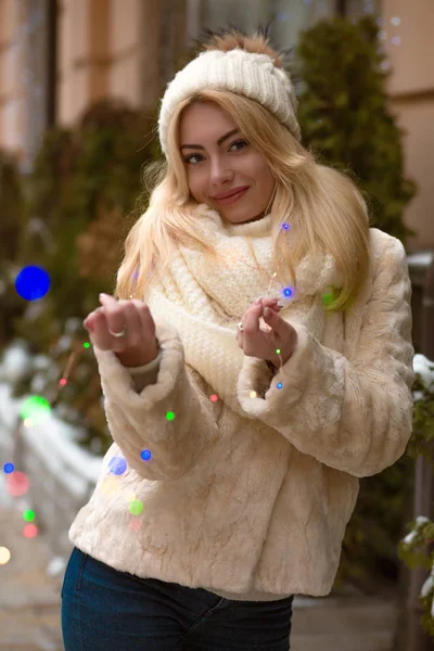 Menina loira bonita vestindo chapéu de malha branco e cachecol, posando w — Fotografia de Stock