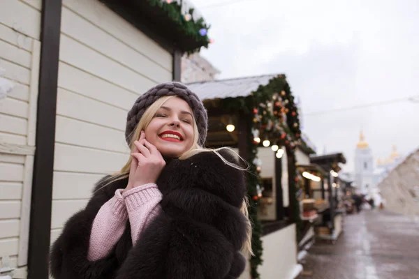 Gatan porträtt av glad ung kvinna som bär snygga stickade ha — Stockfoto