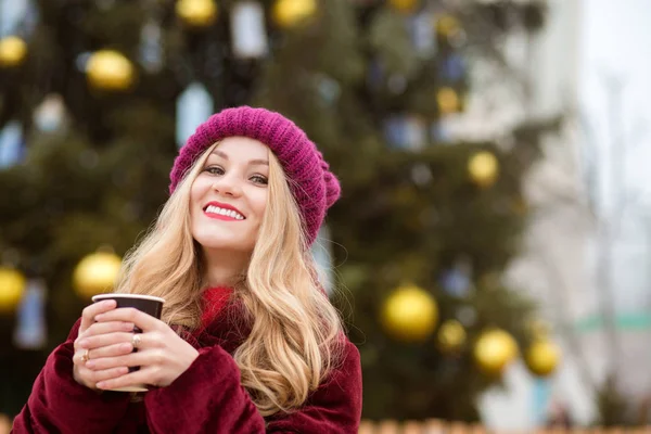 Emocional mujer rubia bebiendo café cerca del árbol de Navidad en —  Fotos de Stock