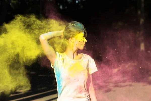 Härlig flicka poserar med gula och rosa Holi pulver exploderande — Stockfoto