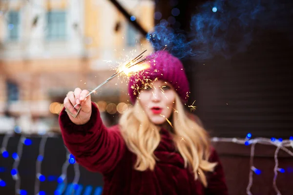 Surprised blonde girl holding burning Bengal lights at the Chris — Stock Photo, Image