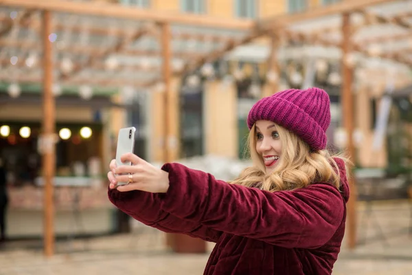 Positive blonde woman having fun and making self portrait at the — Stock Photo, Image