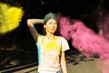 Çekici kız sarı ve pembe Holi toz explodi ile poz