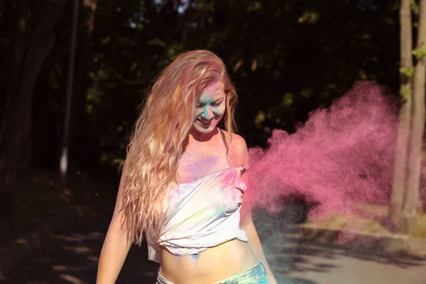 Modelo jovem feliz coberto com tinta seca colorida em Holi festiv — Fotografia de Stock