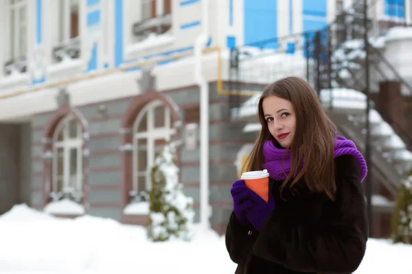 Красивая молодая женщина, одетая в теплое пальто, шарф и питье — стоковое фото