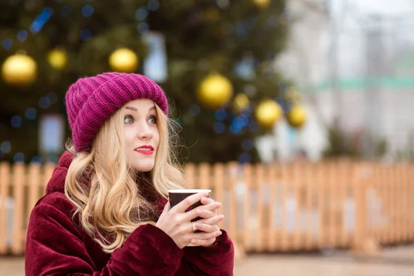 Pretty blonde woman drinking coffee near the Cristmas tree on th — Stock Photo, Image