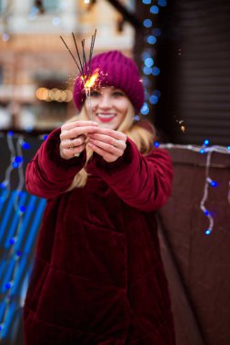 Sevimli sarışın kız İsa'parlayan Bengal ışıklar holding