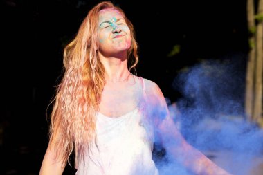 Uzun kıvırcık saçlı Holi festival kutluyor komik genç kadın