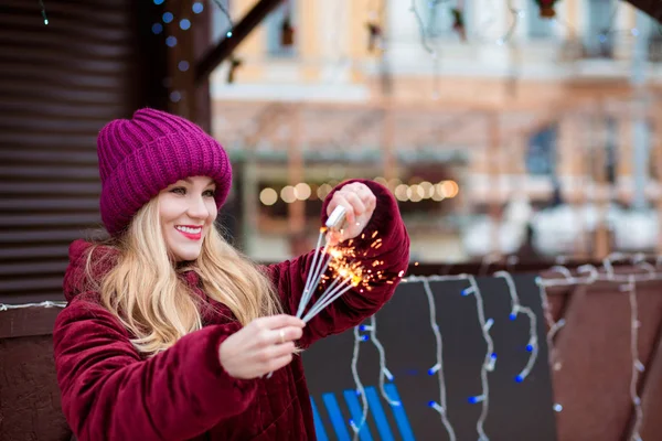 Happy blonde girl dressed in stylish clothes, sets fire to spark — Stock Photo, Image