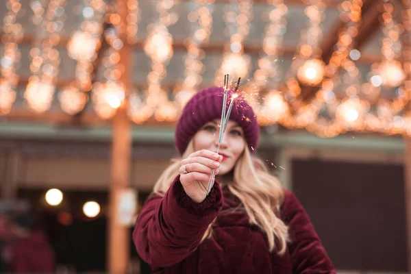 Gorgeous blonde girl holding glowing Bengal lights at the Christ — Stock Photo, Image