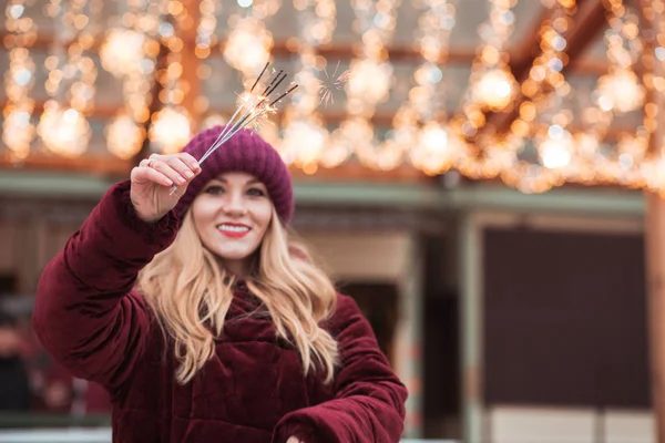 Amazing blonde girl holding glowing Bengal lights at the Christm — Stock Photo, Image