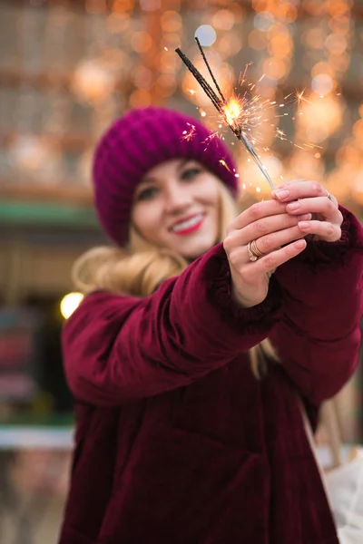 Stunning blonde girl holding glowing Bengal lights at the Christ — Stock Photo, Image