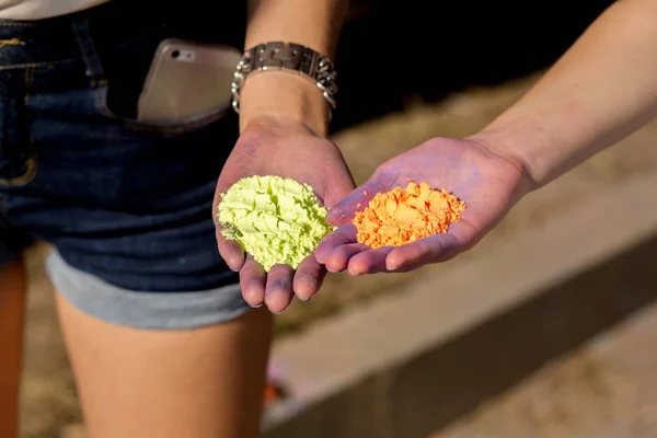 Vértes lövés a zöld és narancs Holi száraz p női kezei — Stock Fotó
