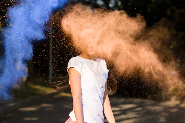 Expressive young asian woman having fun with Holi paint explodin — Stock Photo, Image
